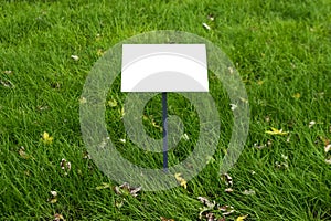 Empty sign board on grass with space for caption. Property house for sale sign board. Notice board with copyspace for prohibition