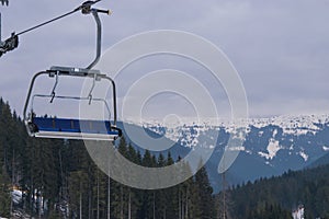 Empty ski chairlift with beautiful mountains forest on the background