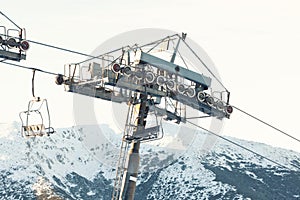 Empty ski lift chair going down from the very top of a mountain