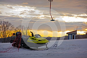 Empty ski lift and snowmobile during sunrise in a ski resort