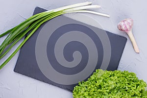 Empty slate and fresh vegetables.