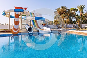 Empty small aquapark sliders with pool and palm trees at the morning, Tunisia