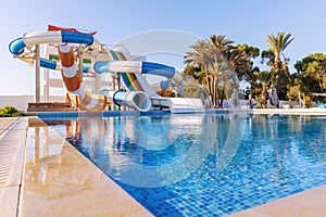 Empty small aquapark sliders with pool and palm trees at the morning, Tunisia