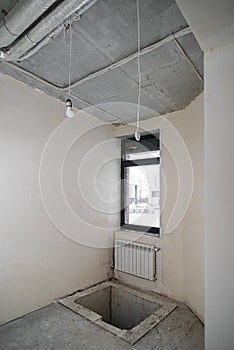 Empty small room for technical needs in a newly built residential building. Pipe wiring