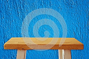 Empty small table in front of blue wall background