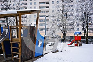 Empty snow children playdround with benches, slide and turnstile