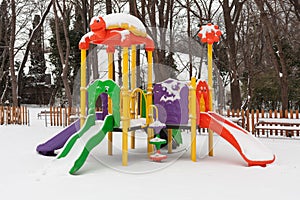 Empty snow children playground in the park in winter time