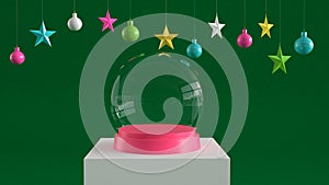 Empty snow glass ball with pink tray on white podium on green canvas background with hanging colorful balls and stars ornaments.