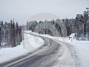 Empty snowy Northern winter road, turn on the road