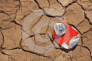 Empty soda can on dry soil