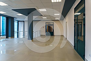 An empty space with railings and large windows. The modern interior of the lobby of the office building. A lighted long corridor