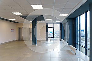 An empty space with railings and large windows. The modern interior of the lobby of the office building. A lighted long corridor