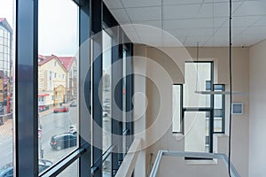 An empty space with railings and large windows. The modern interior of the lobby of the office building. A lighted long corridor