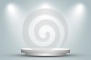 Round white podium or pedestal in studio room with spotlight in gray background.