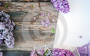 Empty space wooden background with lilac bunch flowers and white empty list, banner mockup