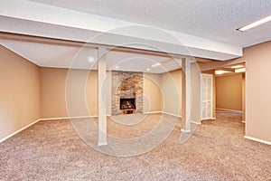 Empty spacious room with brick fireplace and carpet floor