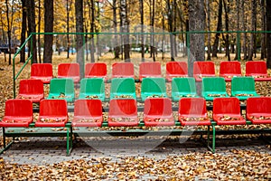 Empty sports stands with red and green seats on an autumn day