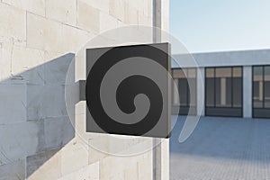 Empty square black stopper on concrete building. Bright city with sunlight background. Ad, pub, cafe, or restaurant banner. Mock