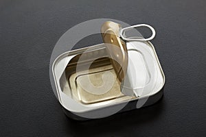 Empty square tin can for food with open lid and ring pull