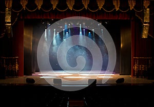 An empty stage of the theater, lit by spotlights and smoke