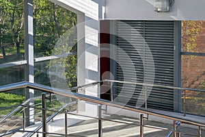 empty staircase with metal handrails of covered aboveground pedestrian crosswalk with full-length windows