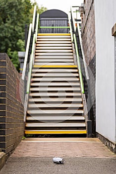 Empty stairs to British rural train station and waste beer can