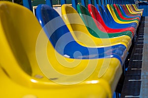 Empty stands, a grandstand with one row of plastic multi-colored seats, chairs for fans in a sports stadium