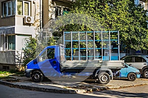 Empty stationary semi truck with glass rack for pane transportation on a city street. PVC windows delivering. Construction and