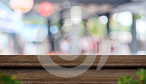 Empty step dark wood table top food stand with blur cafe restaurant background bokeh light and leaf foreground,Mock up for