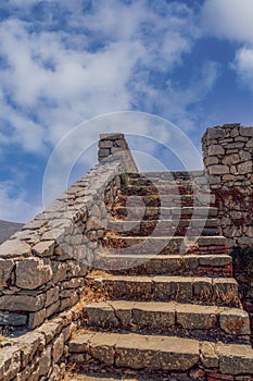 Empty stone old staircase against blue sky with clouds