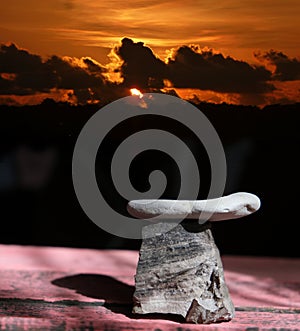 Empty stone podium on dramatic stormy sky background, sunset. Celebration and holidays. Background for design. Space for