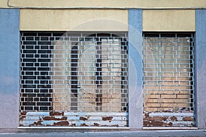 Empty store window of a closed shop, shutter lowered due  to the economic crisis