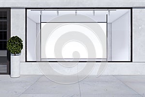 Empty storefront window with white mock up banner for your advertisement and decorative plant. Display, boutique and retail