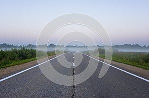 Empty Straight Suburban Asphalt Road In Misty Morning At Dawn