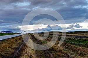 Empty street with cloudy sky and Icelandic Landscape during Sunr