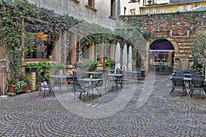 An empty street restaurant in the cozy courtyard of a small European city. The restaurant is waiting for visitors