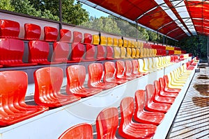 Empty street seats in red and yellow on the podium under a canopy