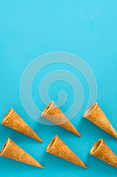 Empty summer ice cream cornets on blue background