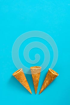 Empty summer ice cream cornets on blue background