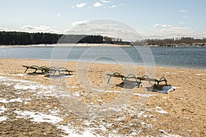 Empty sun beds for relaxing on the beach, the closing of the beach season, early spring on the beach. Sun glare and illumination.