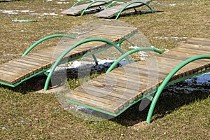 Empty sun beds for relaxing on the beach, the closing of the beach season, early spring on the beach. Sun glare and illumination.