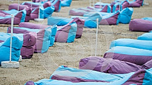 Empty sun loungers on a background of wet sand. Beach season closing concept