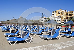 Empty sun loungers on Cabopino beach