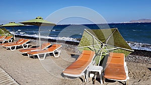 Empty sun loungers on a Greek beach