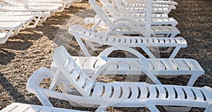 Empty sun loungers on a pebble beach.