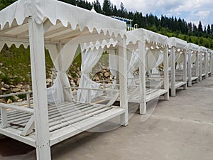 Empty sun loungers stand under a canopy