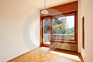 Empty, sunny room interior with wooden floor in country house