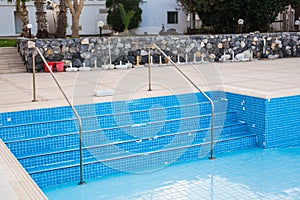 Empty swimming pool with metal ladder.