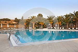 Empty swimmingpool with palmtrees photo