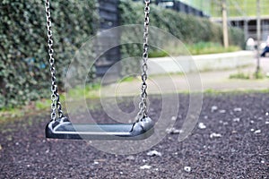 Empty swing with chains on the playground